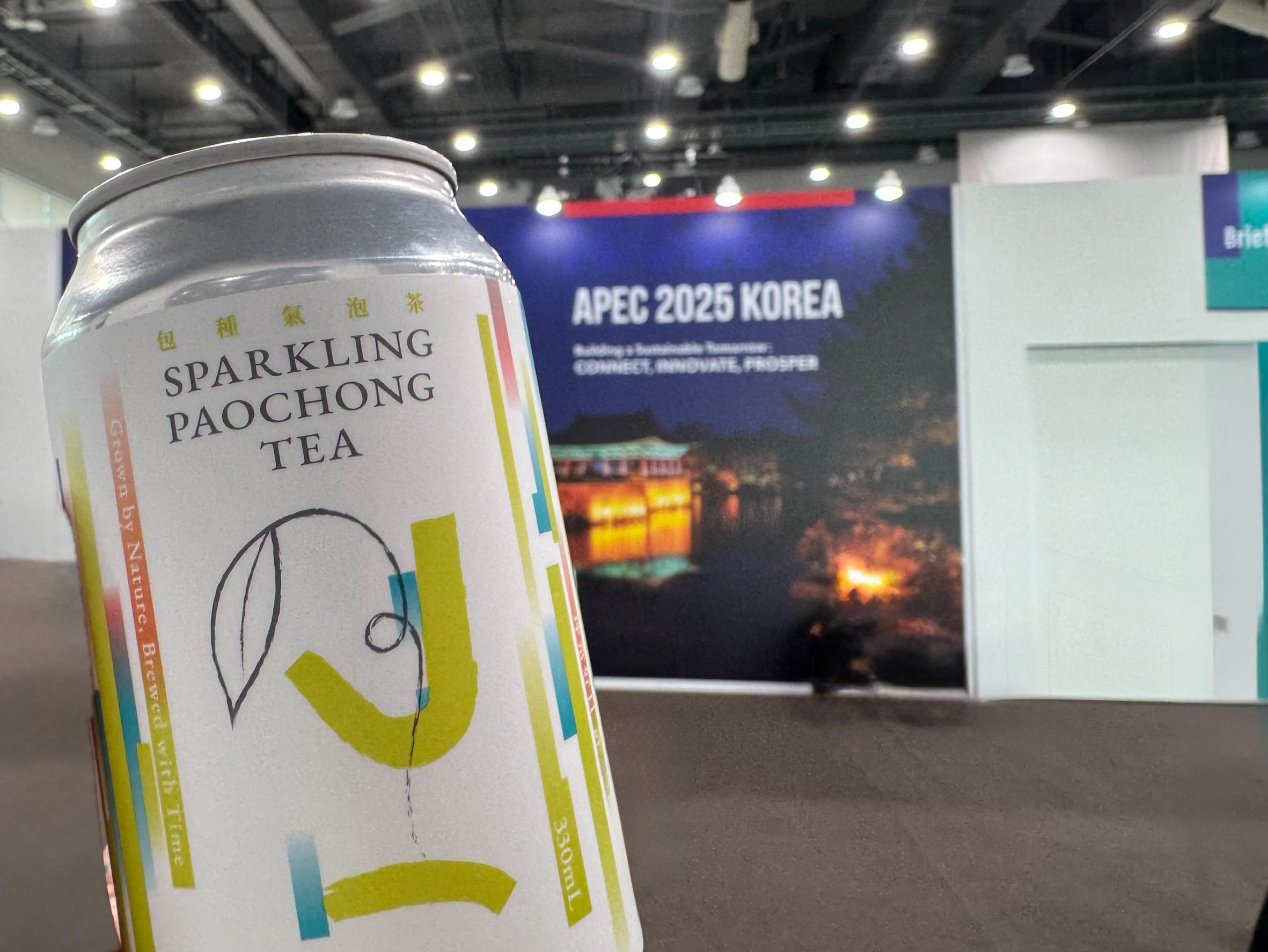 2025 APEC Korea 現場大型看板前手持坪常日Paochong Tea